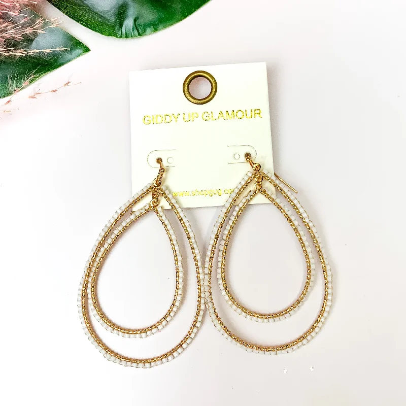 Aged medallion earrings-Double Open Teardrop Gold Tone Earrings with Beaded Outline in White